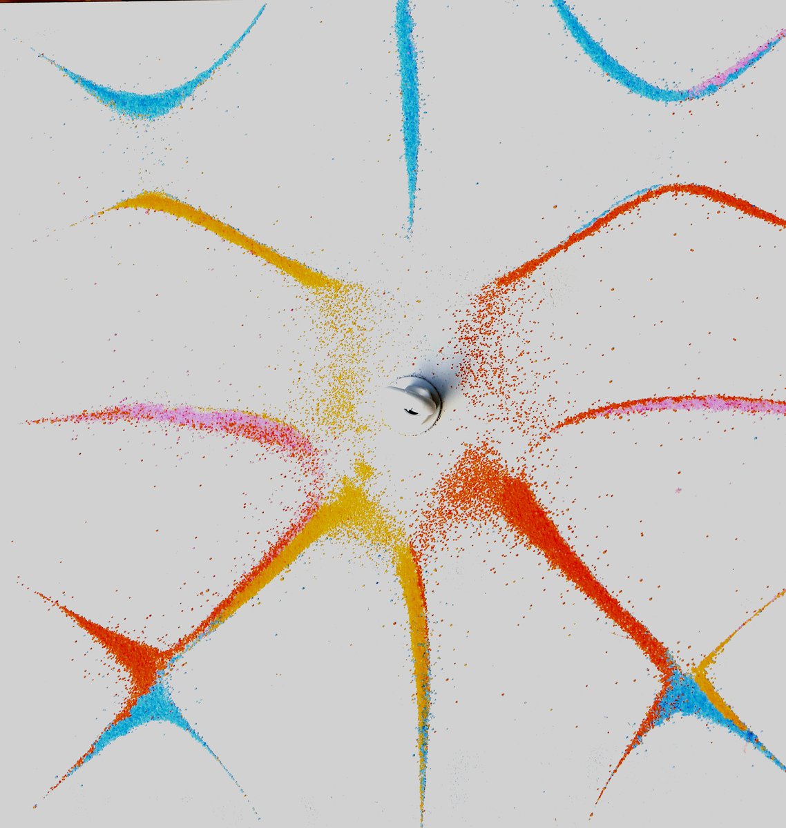 Chladni figure with coloured sand showing a complex star-shaped nodal pattern on a vibrating plate